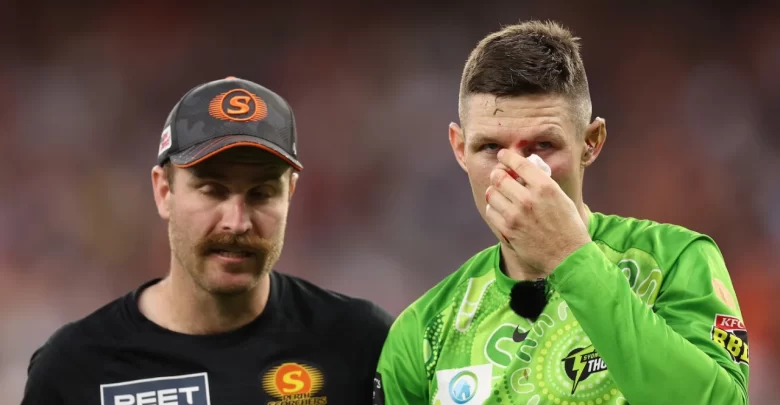 Cameron Bancroft sitting on the field receiving medical attention after a collision during the BBL match.