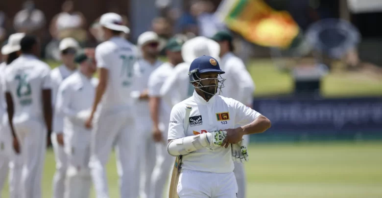 Dimuth Karunaratne raises his bat in celebration after scoring a century in his farewell Test against Australia.